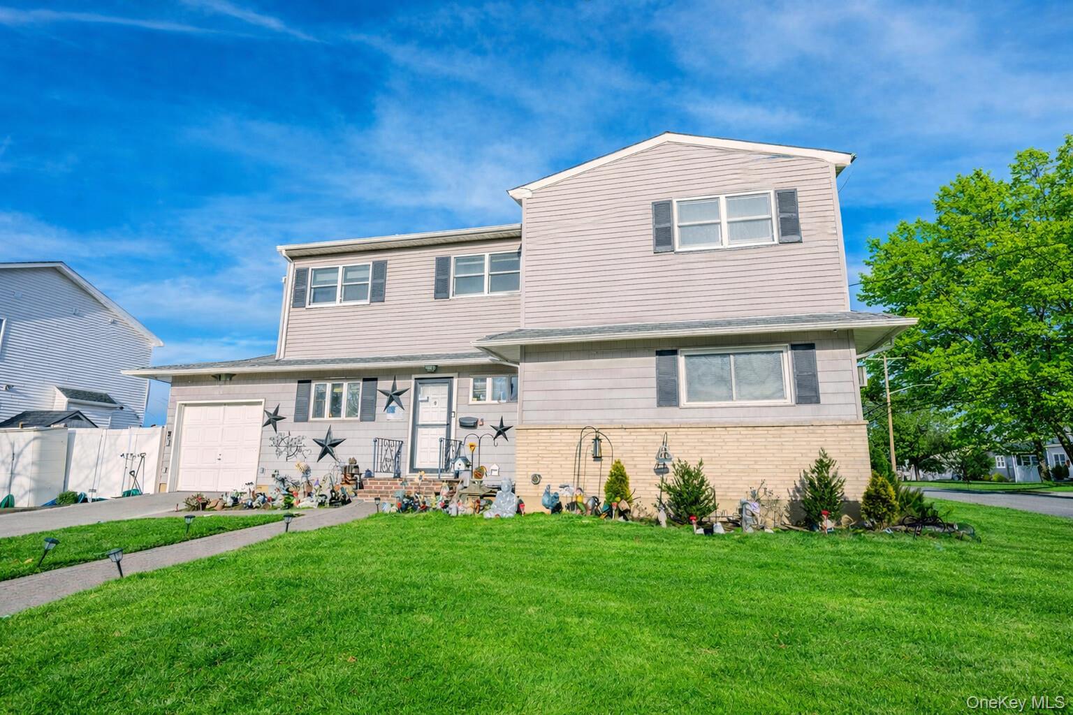 2 Kroll Street Plainview, NY 11803 - Photo 3 of 29 a front view of a house with a yard and garage