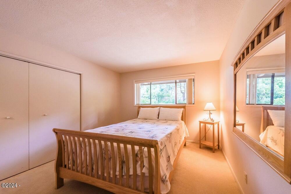 114 Ridge Crest Road Gleneden Beach, OR 97388 - Photo 22 of 40 a bedroom with a bed and a table with lamp