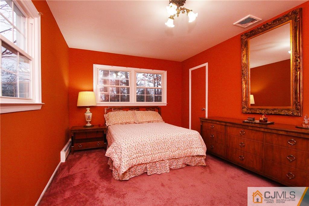 9 Cardinal Avenue Edison, NJ 08820 - Photo 16 of 20 a bedroom with a large bed and a chandelier