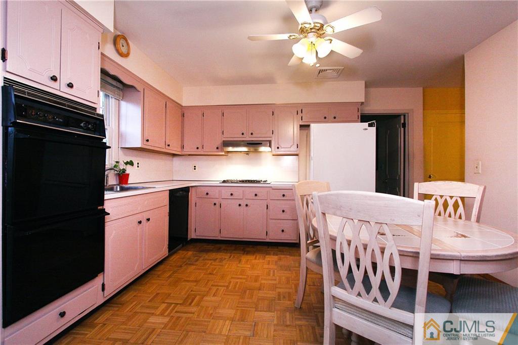 9 Cardinal Avenue Edison, NJ 08820 - Photo 8 of 20 a kitchen with a dining table chairs refrigerator and cabinets