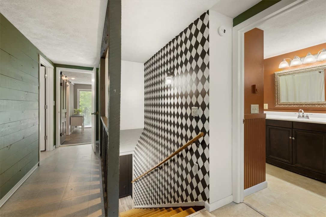 5120 Wheelock Road Troy, OH 45373 - Photo 25 of 67 This interior hallway features a distinctive harlequin wall pattern, leading to a bathroom and another room.