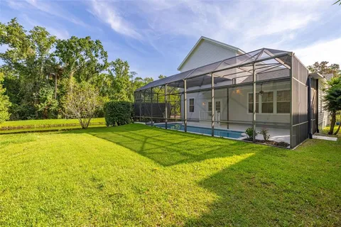 an aerial view of residential houses with outdoor space and trees