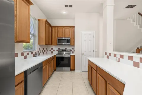 a kitchen with a sink stove top oven and refrigerator