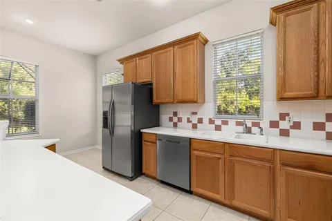 a kitchen with a sink window and refrigerator