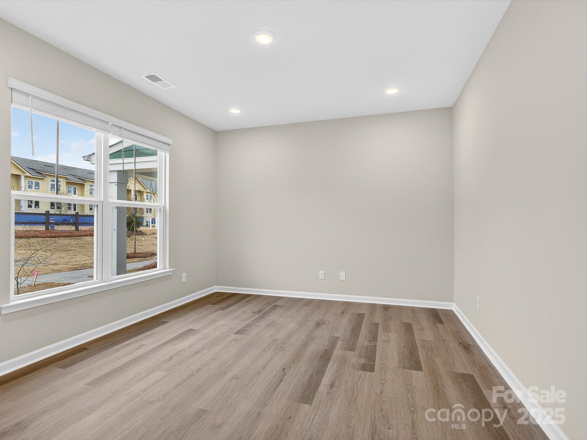 11439 Prosperity Church Road Huntersville, NC 28078 - Photo 6 of 34 an empty room with wooden floor and windows