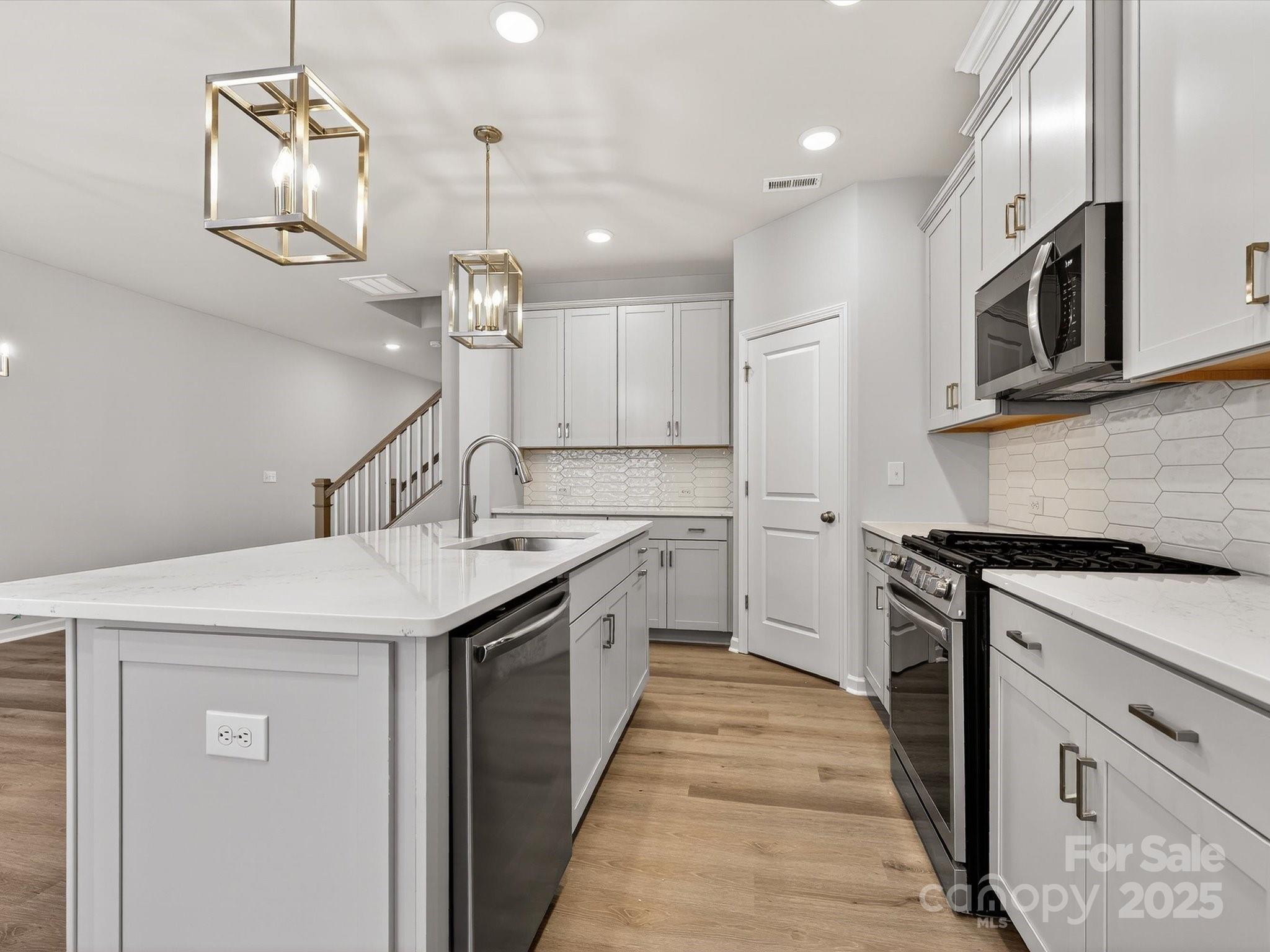 11439 Prosperity Church Road Huntersville, NC 28078 - Photo 10 of 34 a kitchen with stainless steel appliances granite countertop a sink a stove and a wooden floors