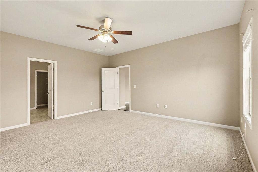 4475 Clubside Drive Gainesville, GA 30504 - Photo 17 of 36 an empty room with chandelier fan and windows