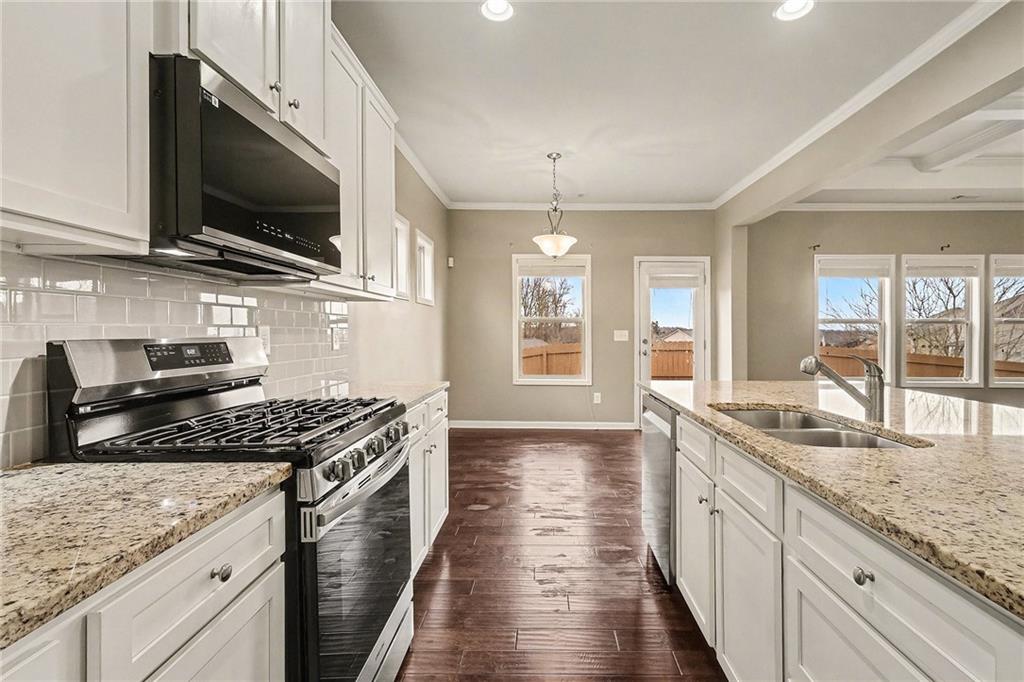 4475 Clubside Drive Gainesville, GA 30504 - Photo 9 of 36 a kitchen with granite countertop a sink and a stove top oven