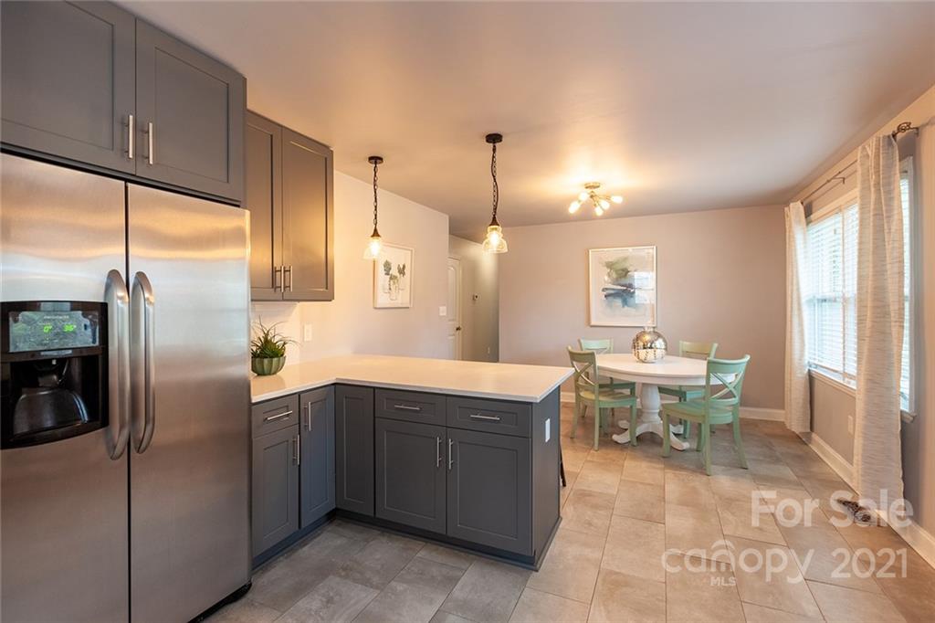 5110 Auburndale Road Charlotte, NC 28205 - Photo 13 of 30 a kitchen with a sink a refrigerator and chairs