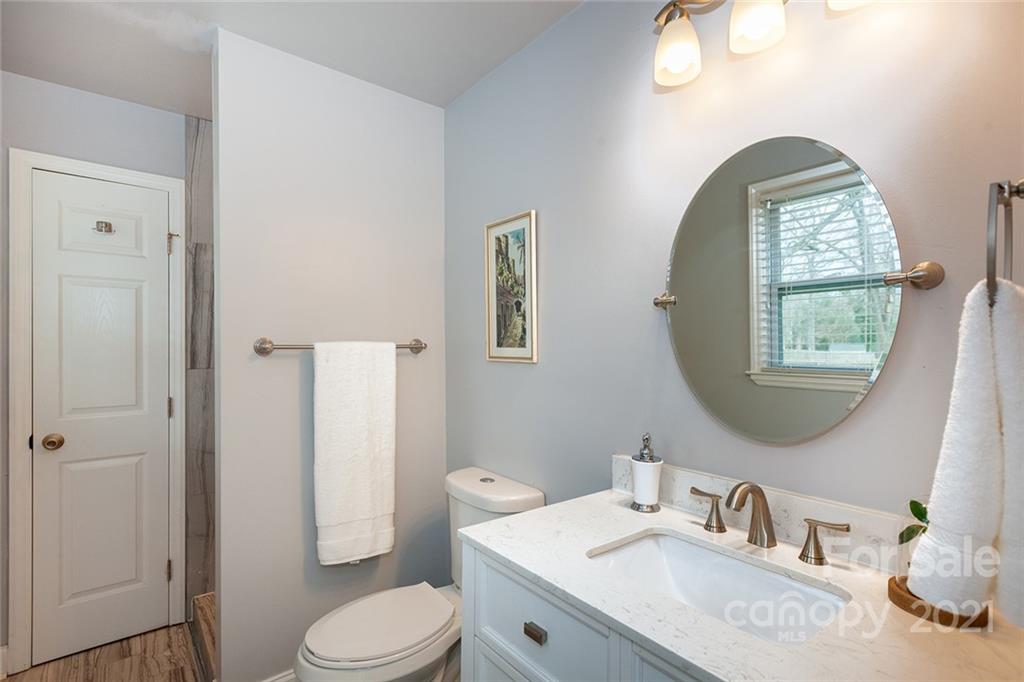 5110 Auburndale Road Charlotte, NC 28205 - Photo 16 of 30 a bathroom with a granite countertop toilet a sink and a mirror