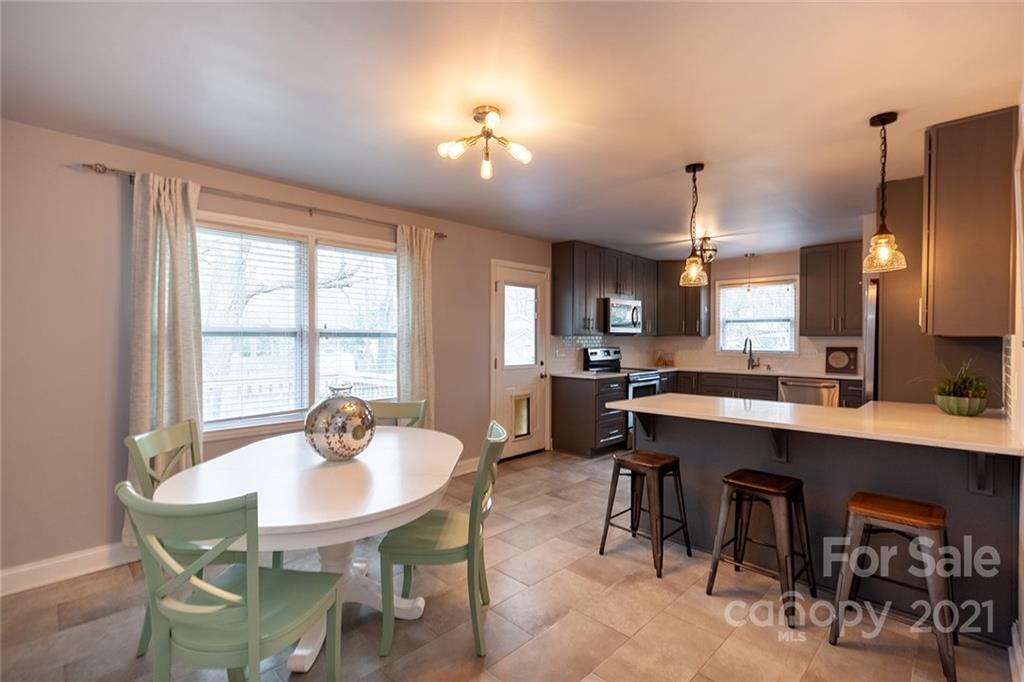 5110 Auburndale Road Charlotte, NC 28205 - Photo 5 of 30 a kitchen with a dining table chairs and refrigerator