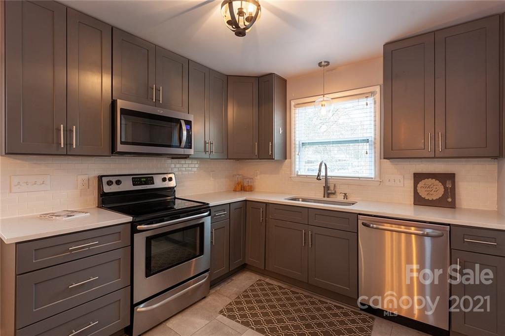 5110 Auburndale Road Charlotte, NC 28205 - Photo 8 of 30 a kitchen with sink a microwave and cabinets