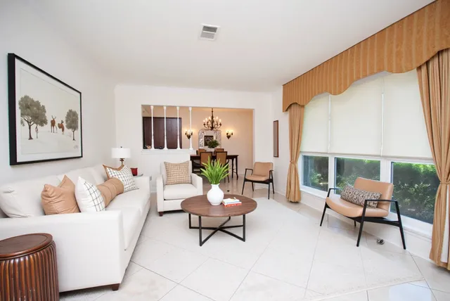 a living room with furniture a lamp and a potted plant