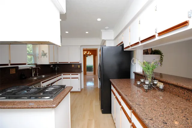 a kitchen with stainless steel appliances granite countertop a sink stove and refrigerator