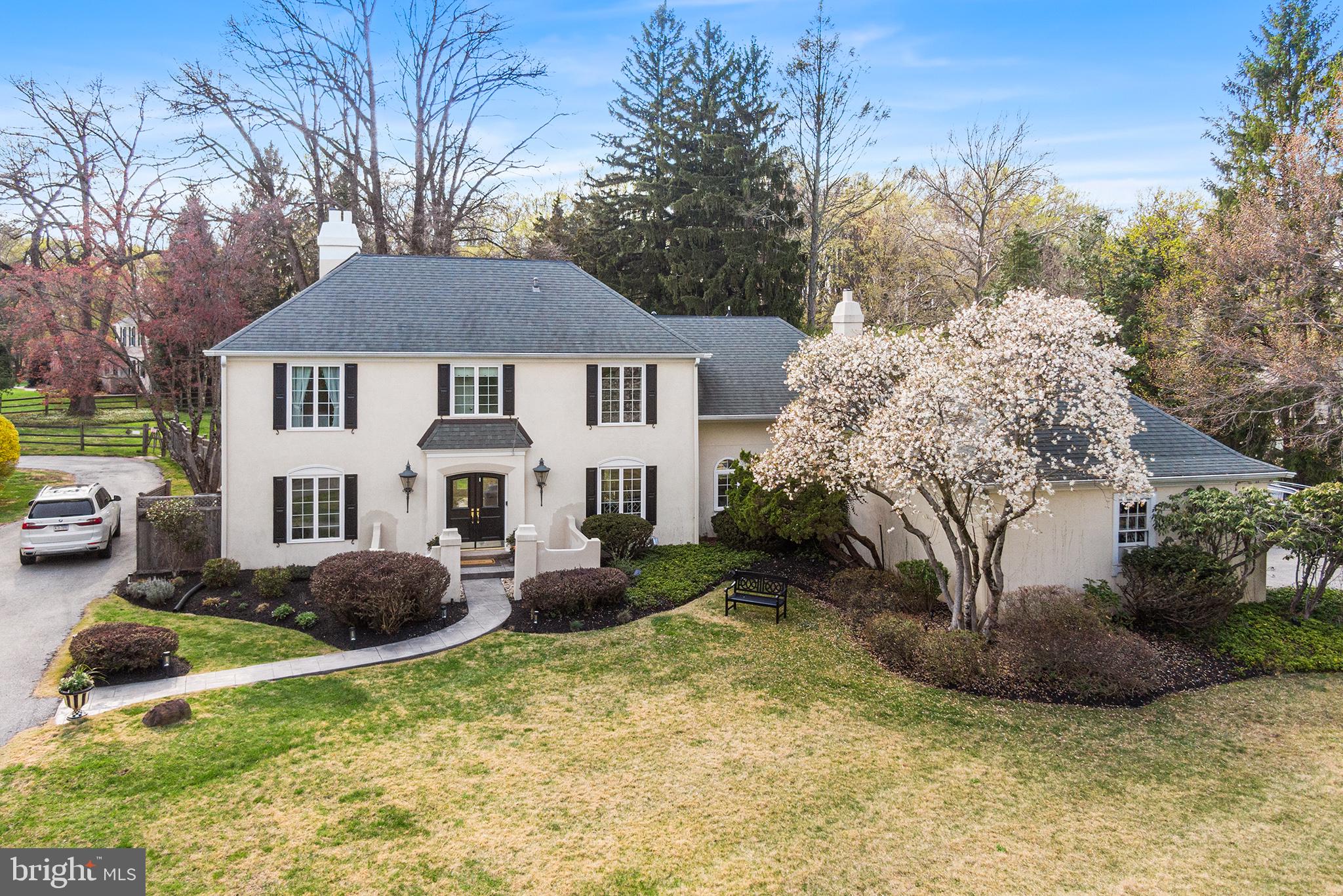 a front view of house with yard and trees in the background