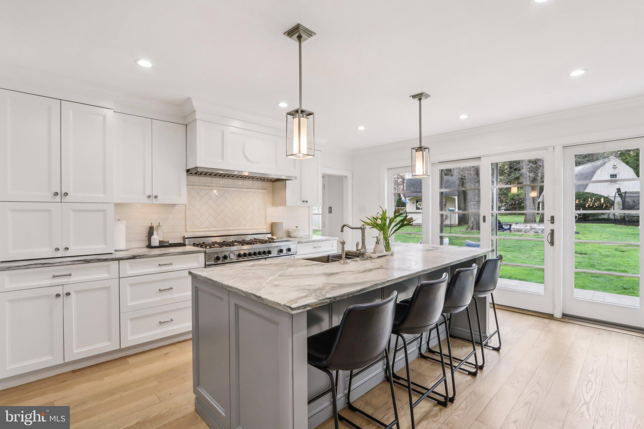 410 North Valley Forge Road Devon, PA 19333 - Photo 19 of 84 a kitchen with stainless steel appliances granite countertop a table chairs stove and white cabinets
