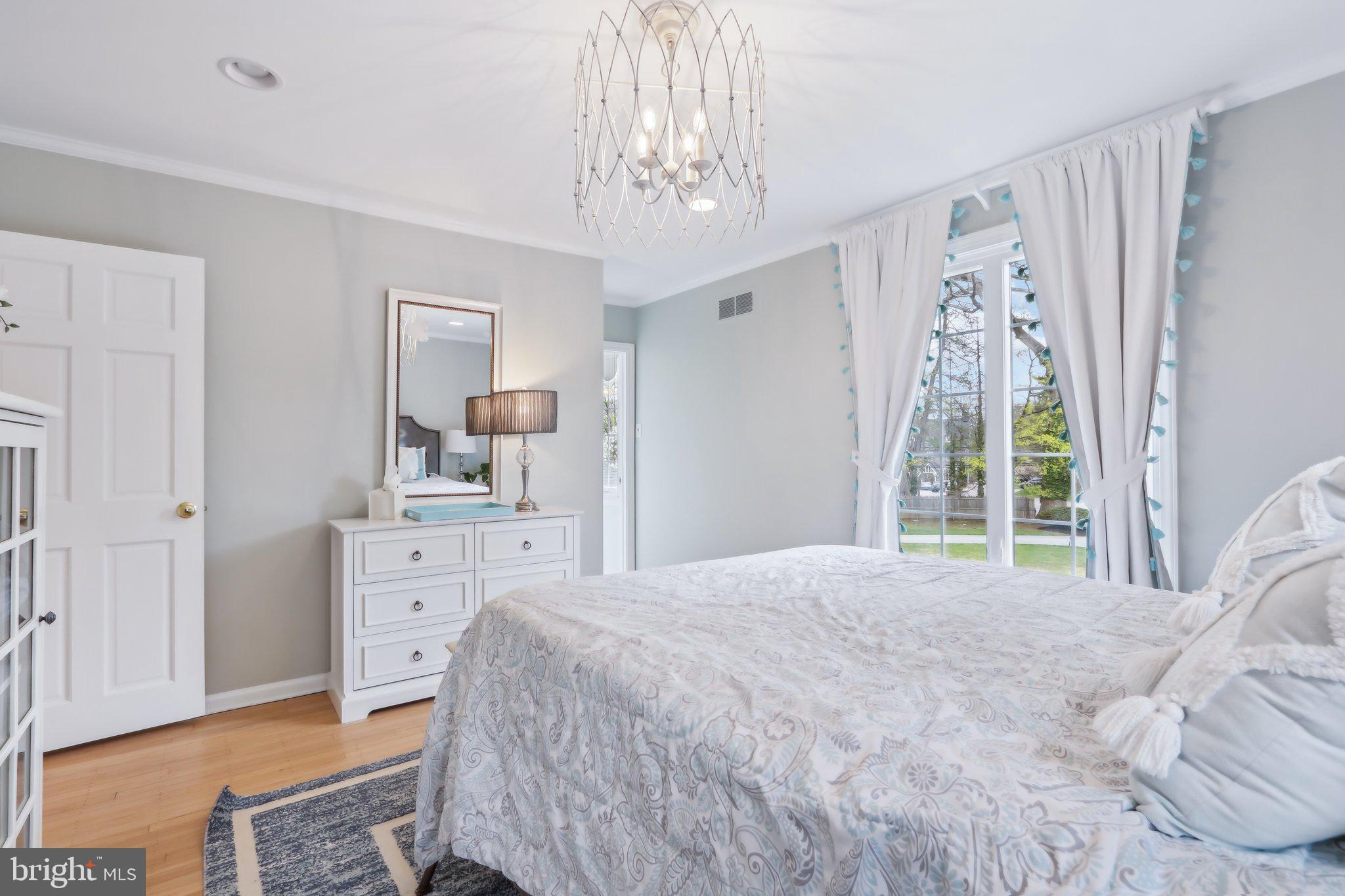 410 North Valley Forge Road Devon, PA 19333 - Photo 56 of 84 a spacious bedroom with a bed a window and a chandelier