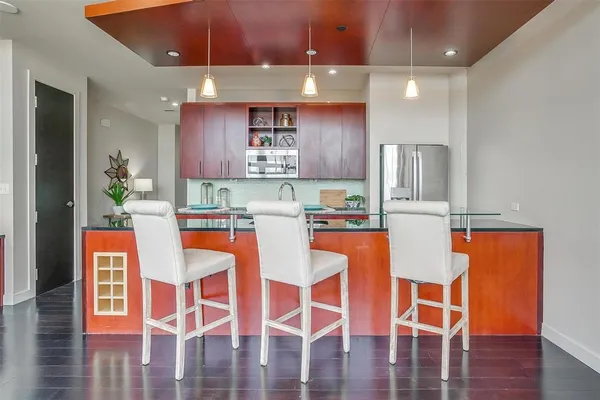 a dining table with chairs and kitchen view