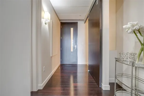 a view of a hallway with wooden floor and staircase