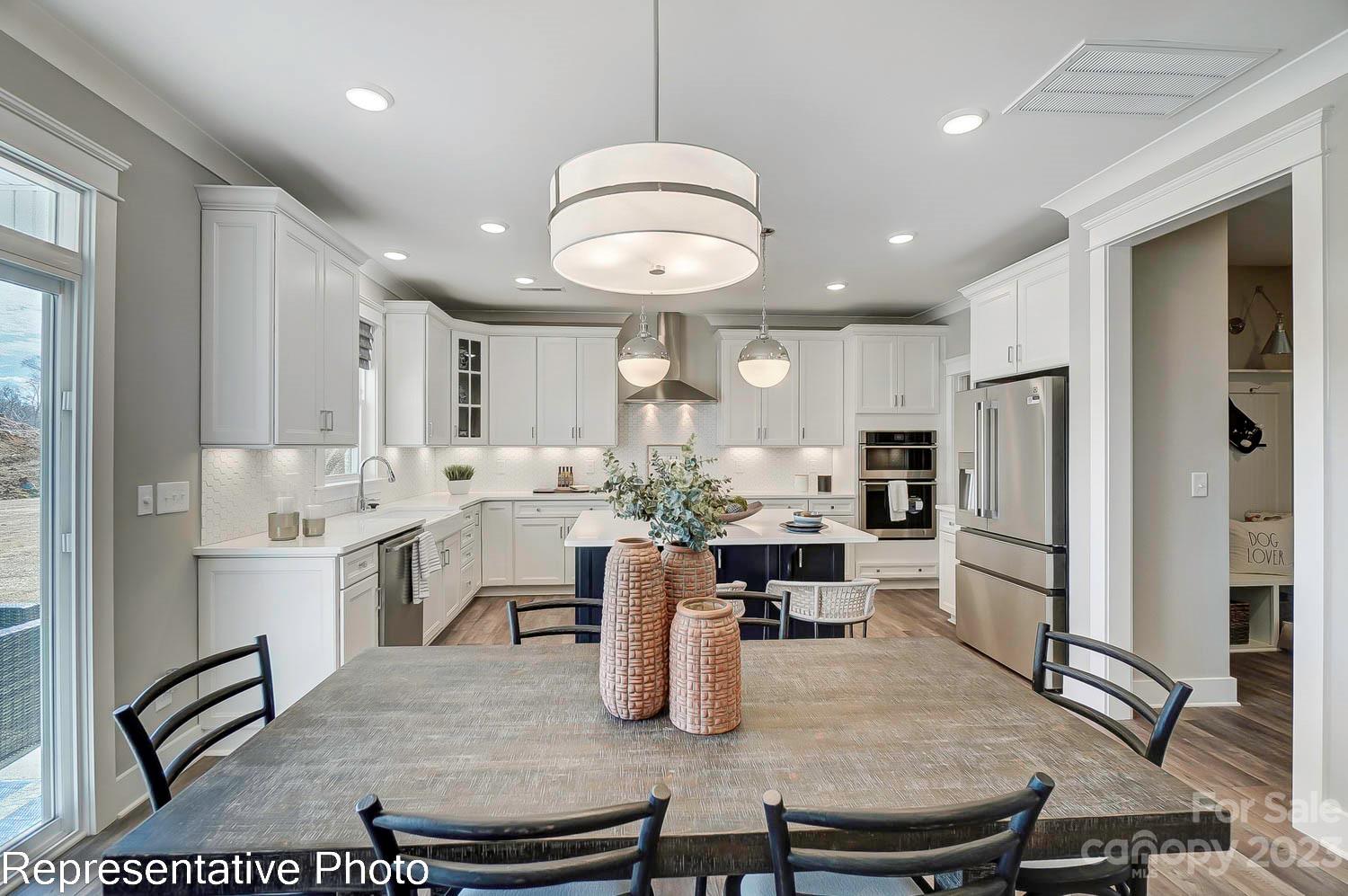 4185 Roberta Road Harrisburg, NC 28075 - Photo 12 of 48 a kitchen with refrigerator cabinets table and chairs