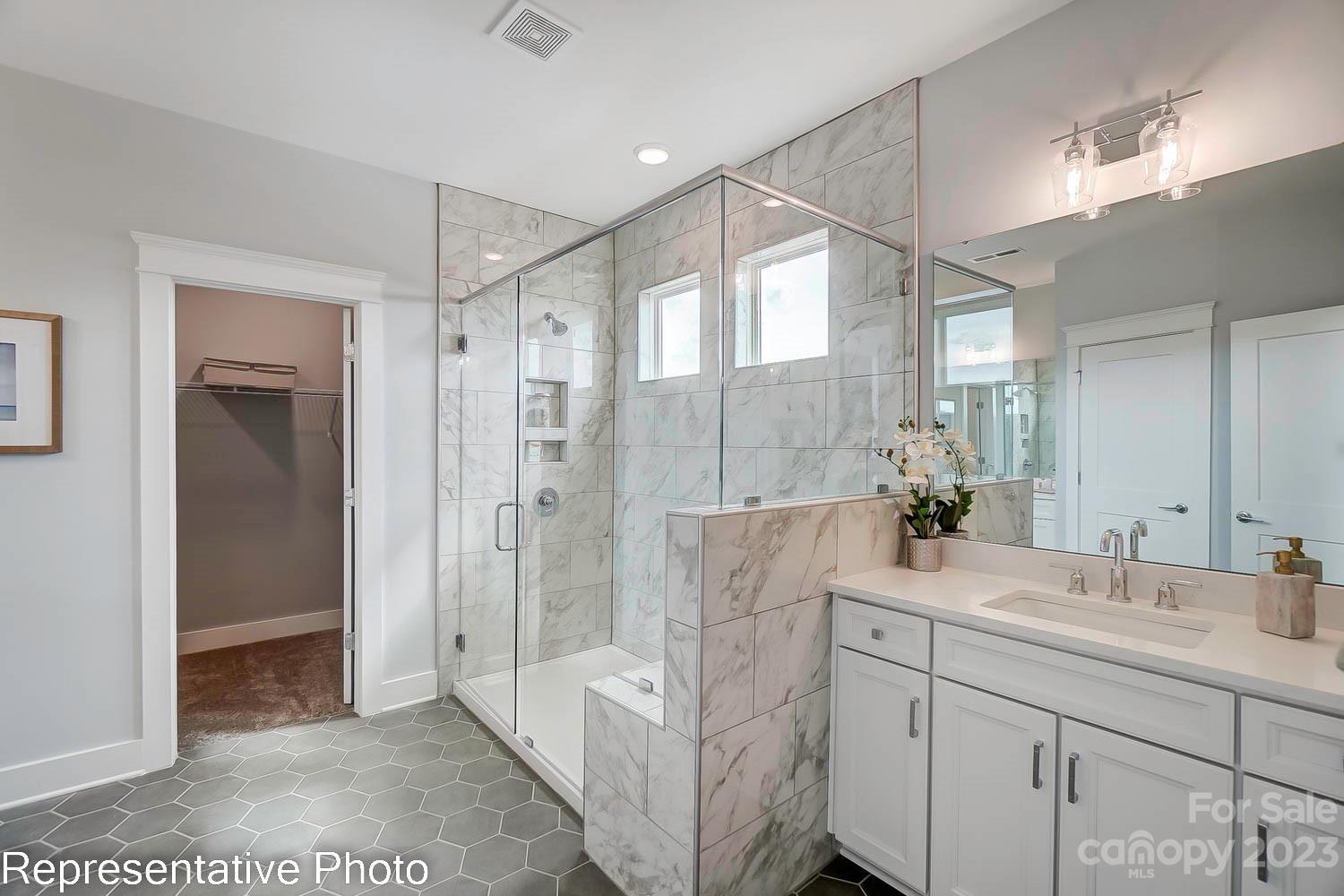 4185 Roberta Road Harrisburg, NC 28075 - Photo 32 of 48 a spacious bathroom with a shower sink and mirror