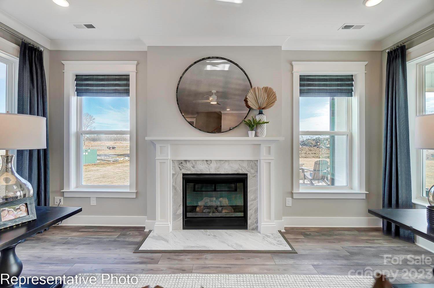 4185 Roberta Road Harrisburg, NC 28075 - Photo 7 of 48 a front view of a livingroom with a fireplace wooden floor and windows
