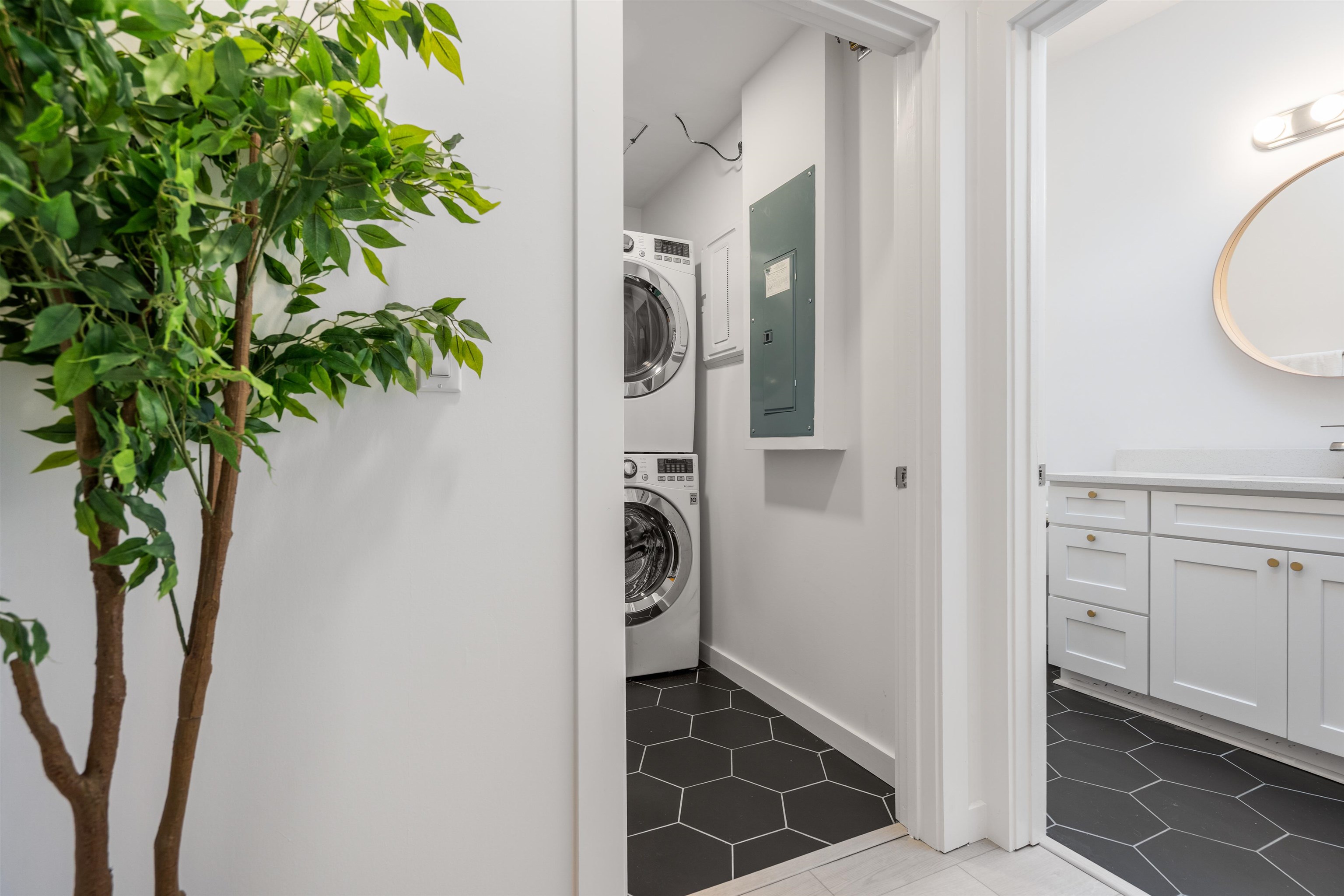 793 Chapin Street St. Augustine, FL 32084 - Photo 16 of 22 Laundry area featuring stacked washer and clothes dryer, dark tile patterned floors, and electric panel