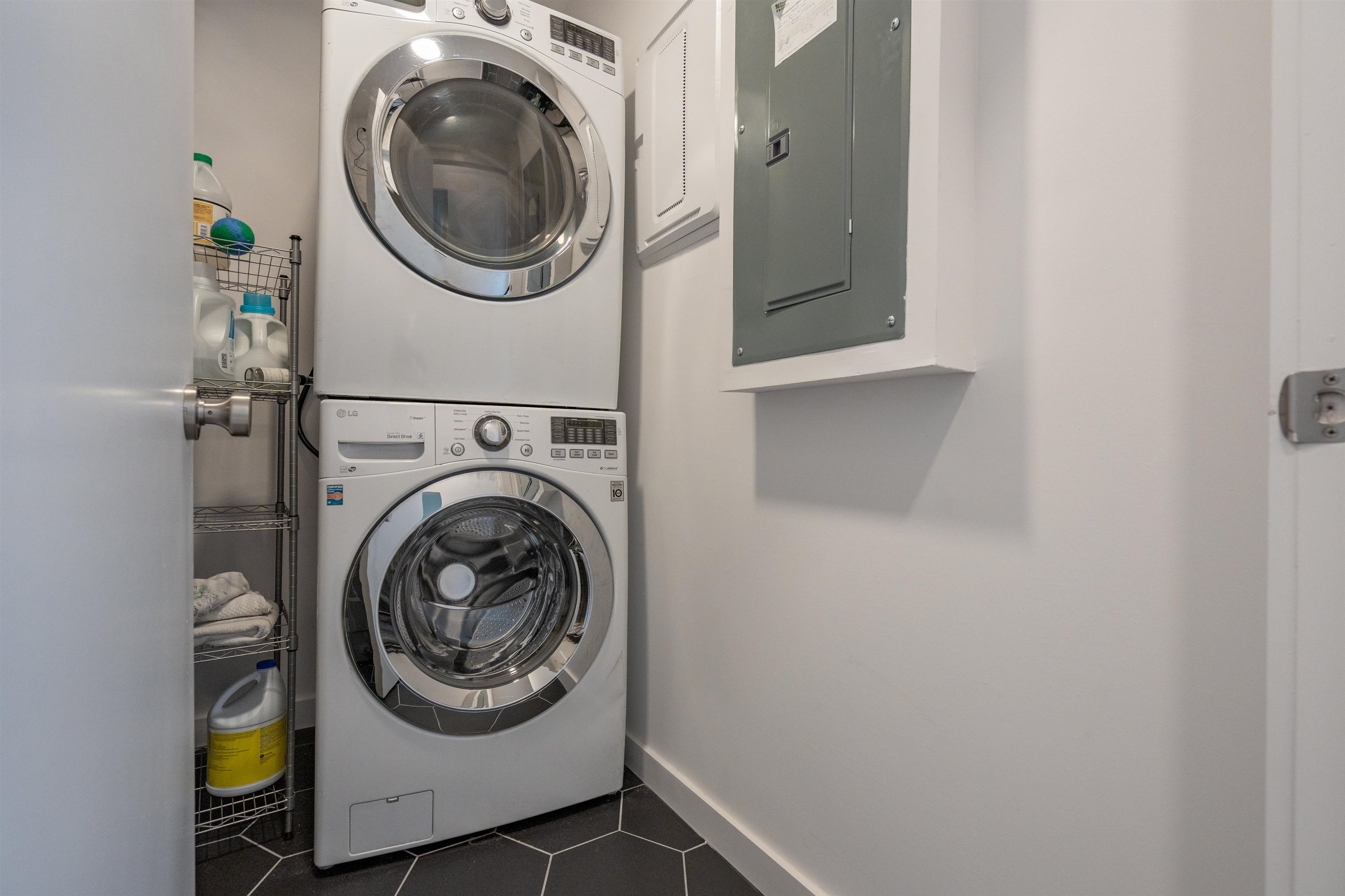 793 Chapin Street St. Augustine, FL 32084 - Photo 17 of 22 Laundry area with dark tile patterned flooring, electric panel, and stacked washer / drying machine