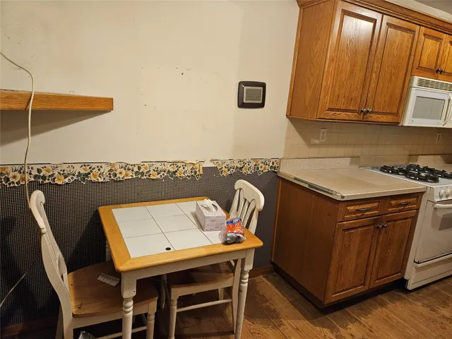 a kitchen with stainless steel appliances granite countertop a sink a microwave cabinets and a dining table