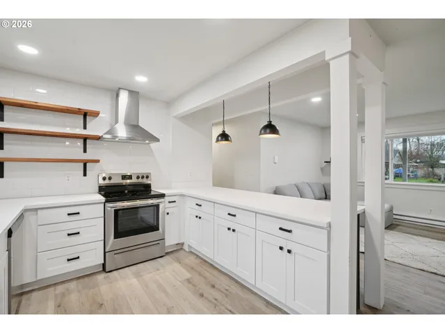 a kitchen with stainless steel appliances white cabinets and a refrigerator