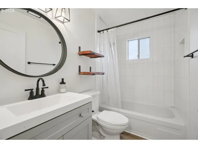 a bathroom with a sink a toilet a mirror and shower