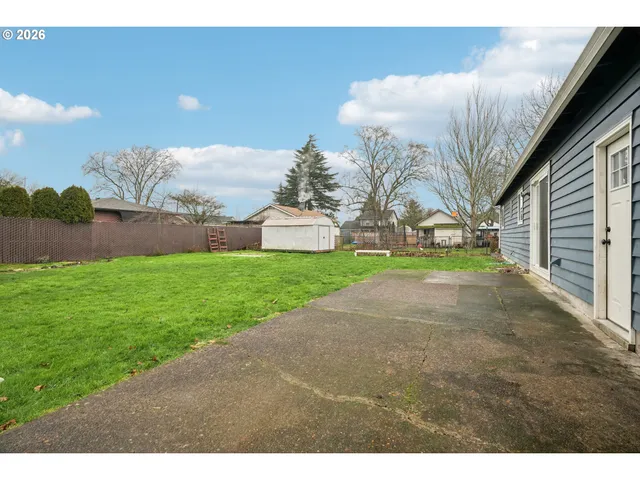 a backyard of a house with table and chairs