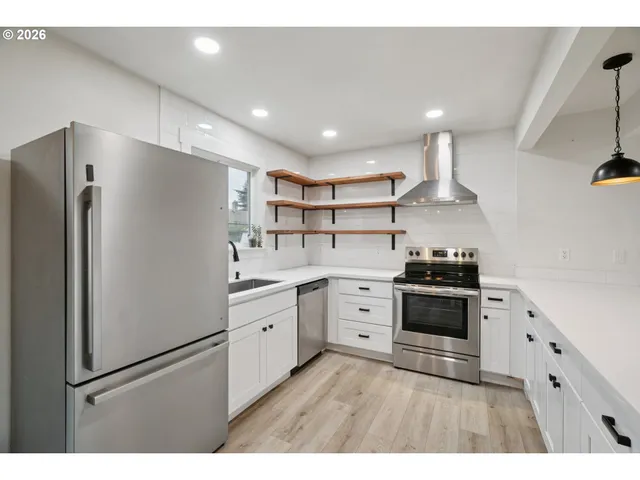 a kitchen with stainless steel appliances granite countertop a refrigerator a stove a sink dishwasher and a refrigerator