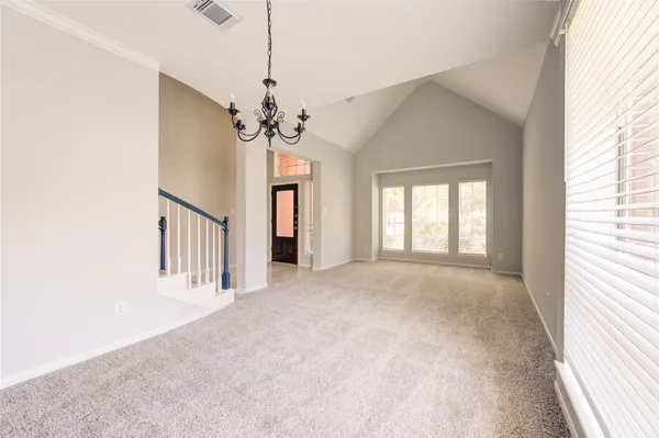 a view of a hallway with windows and chandelier