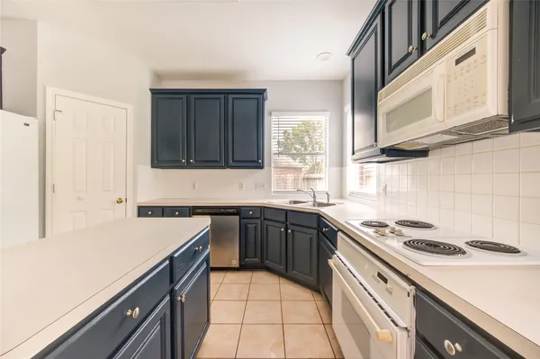 a kitchen with a sink stove top oven and cabinets