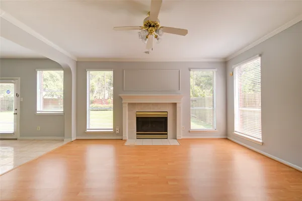 an empty room with windows fireplace and a window