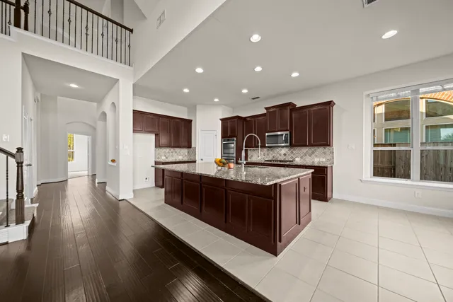 a large kitchen with stainless steel appliances granite countertop a large counter top and a stove