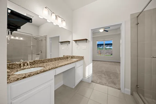 a bathroom with a granite countertop sink a toilet and a mirror