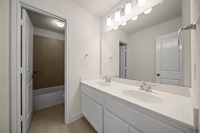 a bathroom with a sink a large mirror and a bathtub