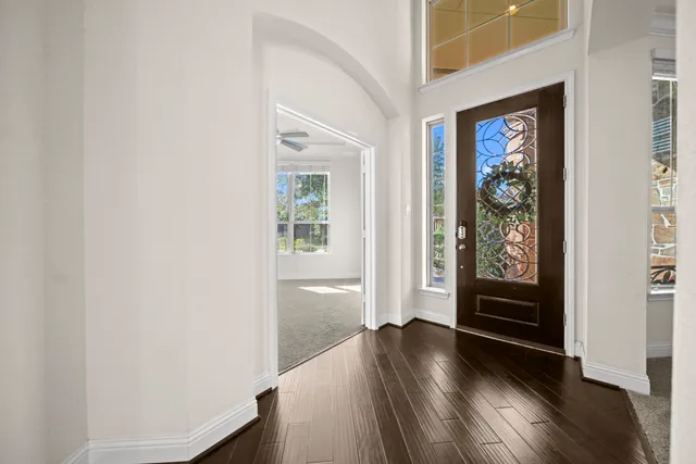 an entryway with wooden floor windows and cabinet