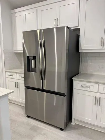 a metallic refrigerator freezer sitting in a kitchen
