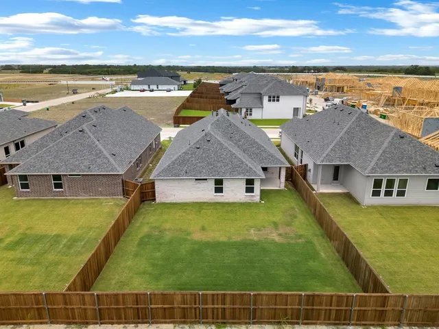 a view of a yard in front of a house with a large tree