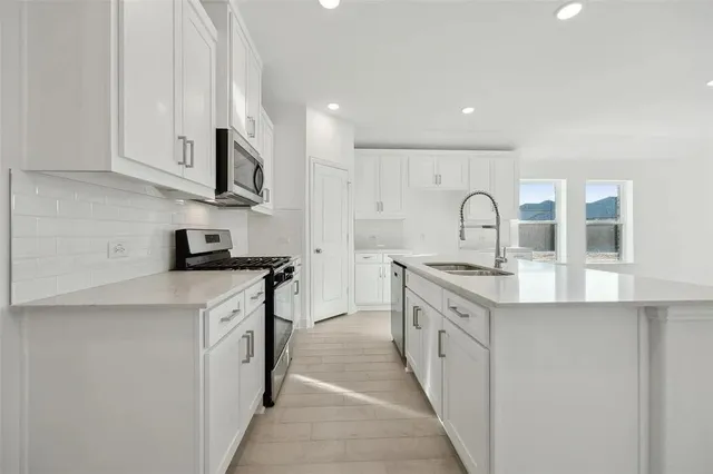 a kitchen with stainless steel appliances granite countertop a sink and cabinets
