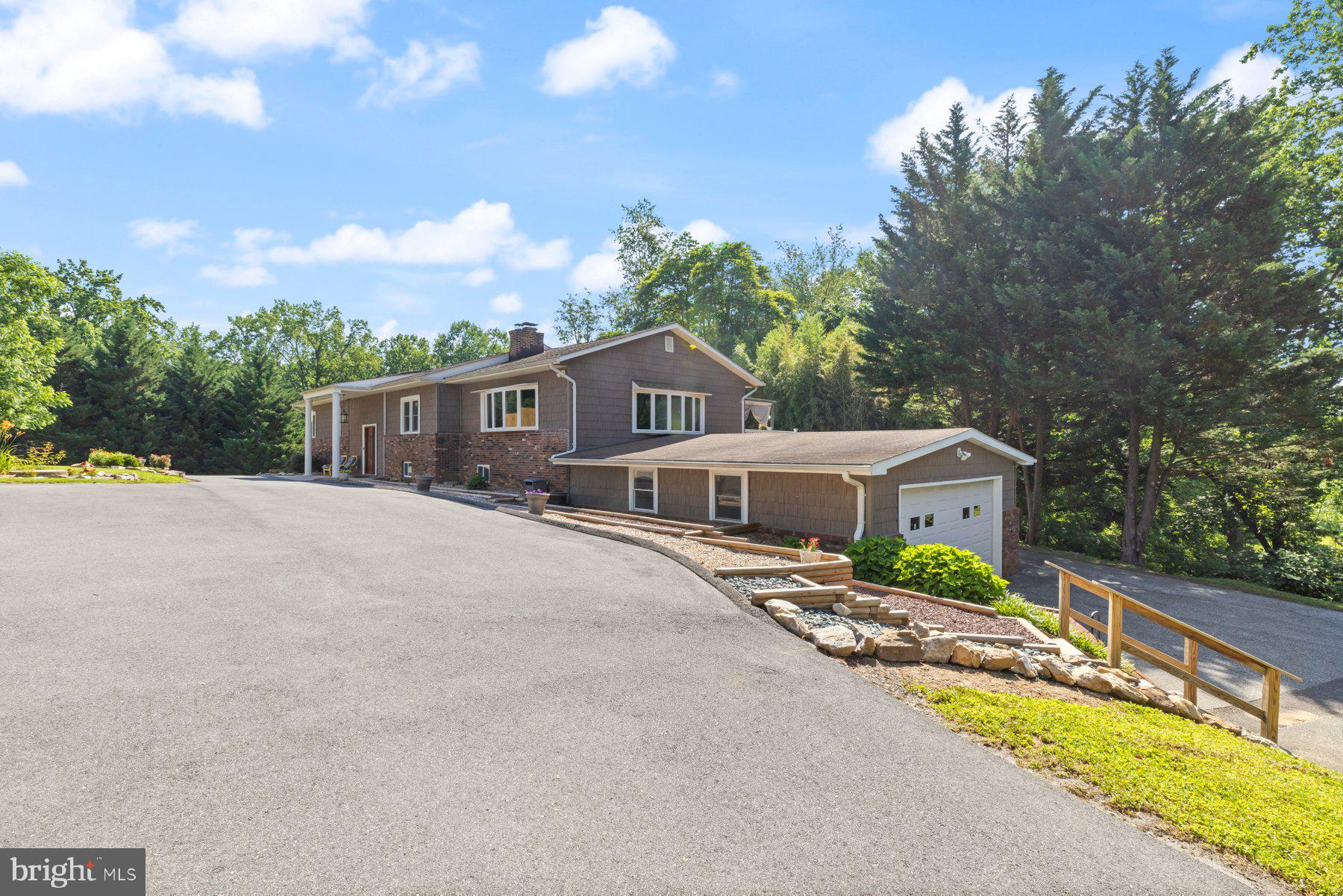 a front view of a house with yard and green space