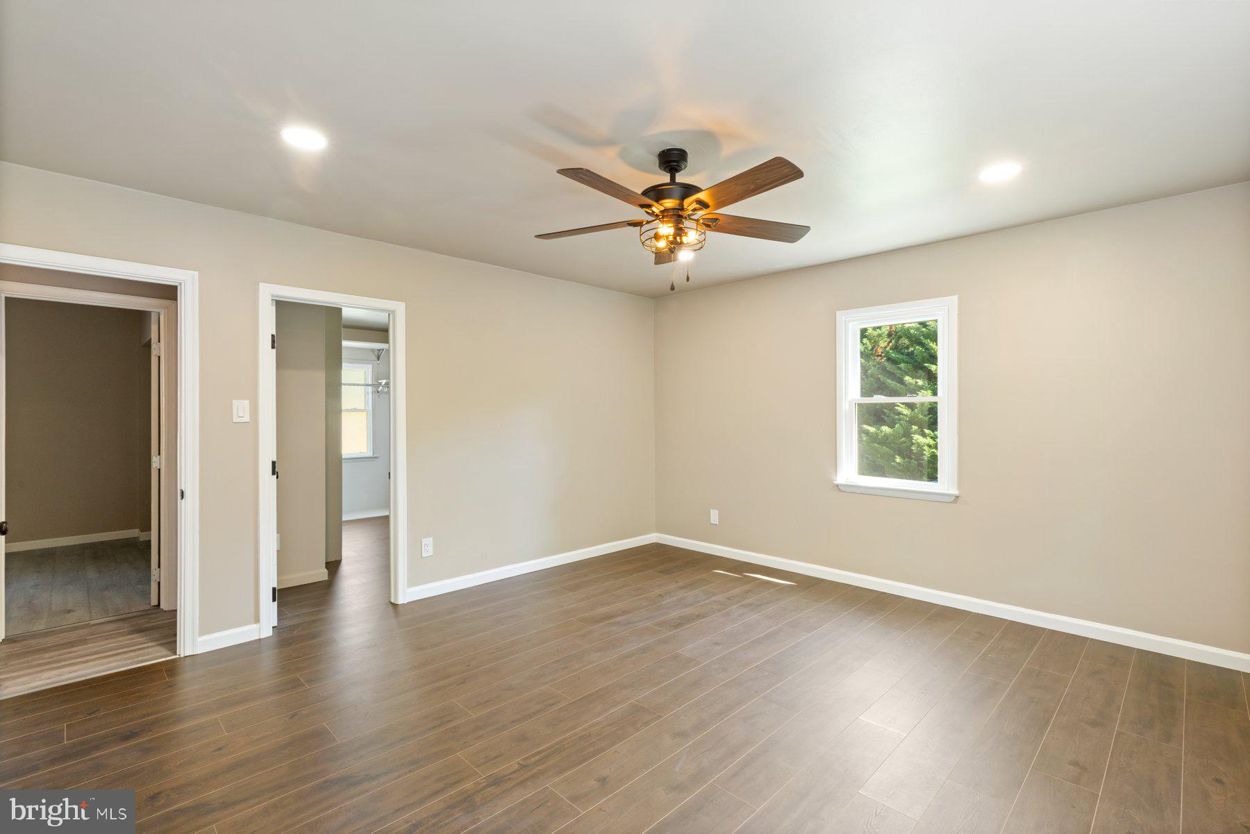13033 Bottom Road Hydes, MD 21082 - Photo 21 of 45 an empty room with wooden floor and a ceiling fan
