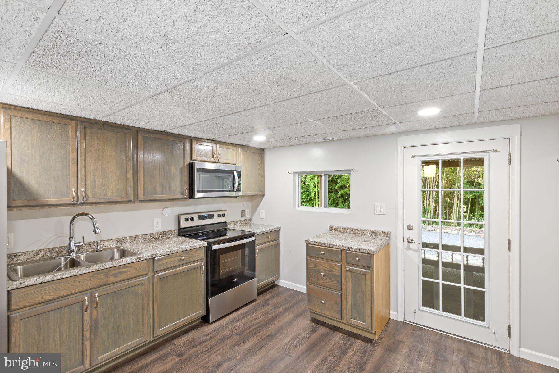 13033 Bottom Road Hydes, MD 21082 - Photo 36 of 45 a kitchen with cabinets stainless steel appliances a sink and wooden floor