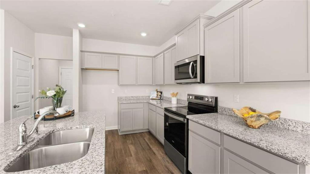 281 Sound Circle Stockbridge, GA 30281 - Photo 16 of 59 a kitchen with stainless steel appliances granite countertop a sink a stove and a refrigerator