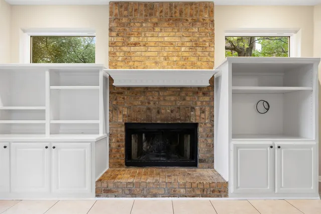 a living room with a fireplace and windows