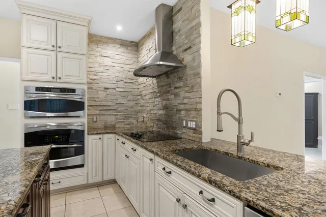 a kitchen with granite countertop a sink stainless steel appliances a counter top space and cabinets