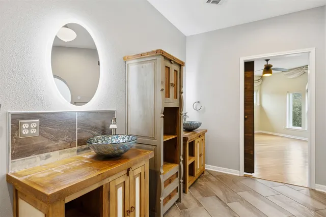 an empty room with a window and a chandelier fan